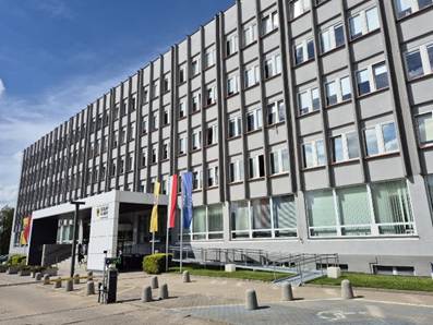 Jasno szary budynek z wieloma oknami. Budynek ma pi�� pi�ter. Do budynku prowadz� schody, nad nimi jest bia�y dach. Po prawej stronie od wej�cia znajduje si� podjazd dla os�b poruszaj�cych si� na w�zkach.